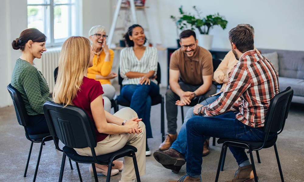 Coed group of patients sitting in a circle during a drug rehab therapy session in Pembroke, MA.