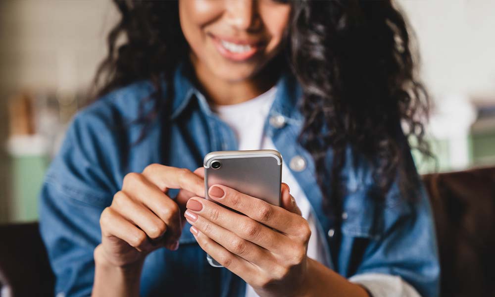 Woman searching on her cell phone for addiction treatment in Mattapoisett