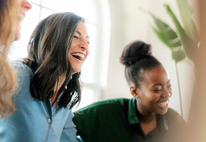 three women smiling with each other during partial hospitalization for depression