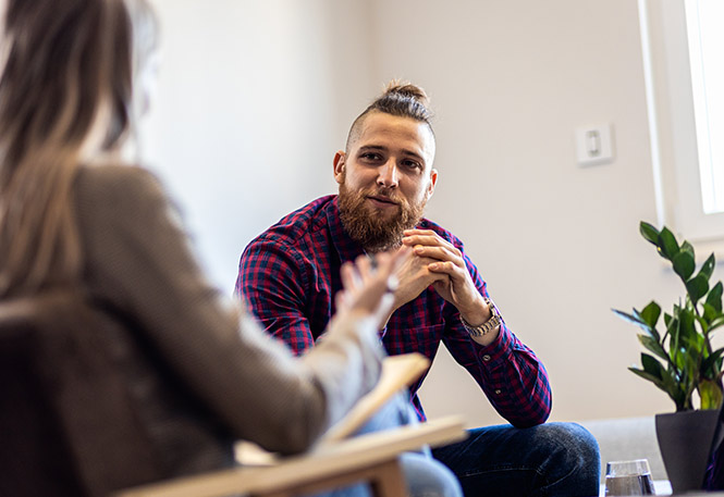Male patient sitting with female therapist during intensive outpatient for depression